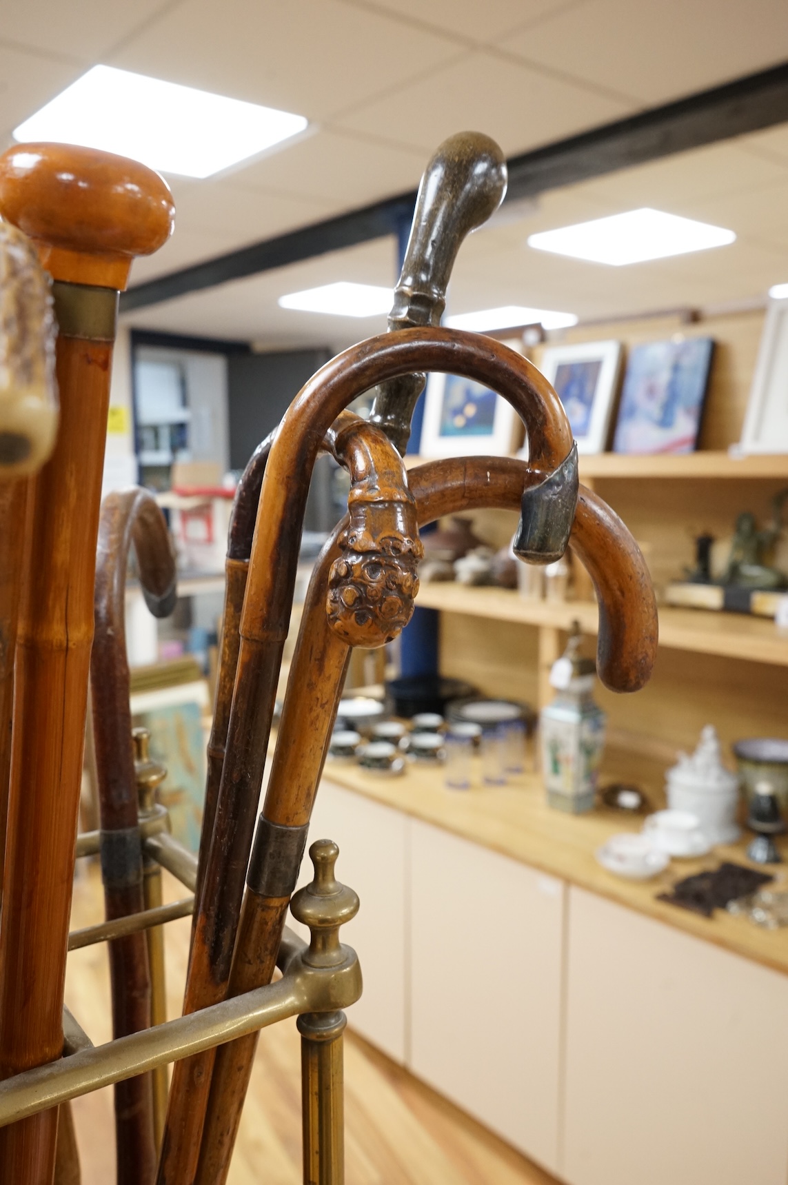 A collection of various walking sticks, some silver mounted and a brass stick stand, 67cm high
